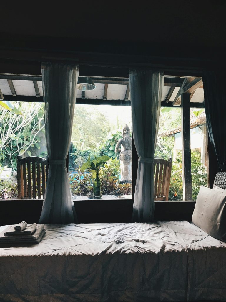 Relaxing bedroom overlooking lush garden in Marga, Bali. Serenity and comfort in a serene setting.