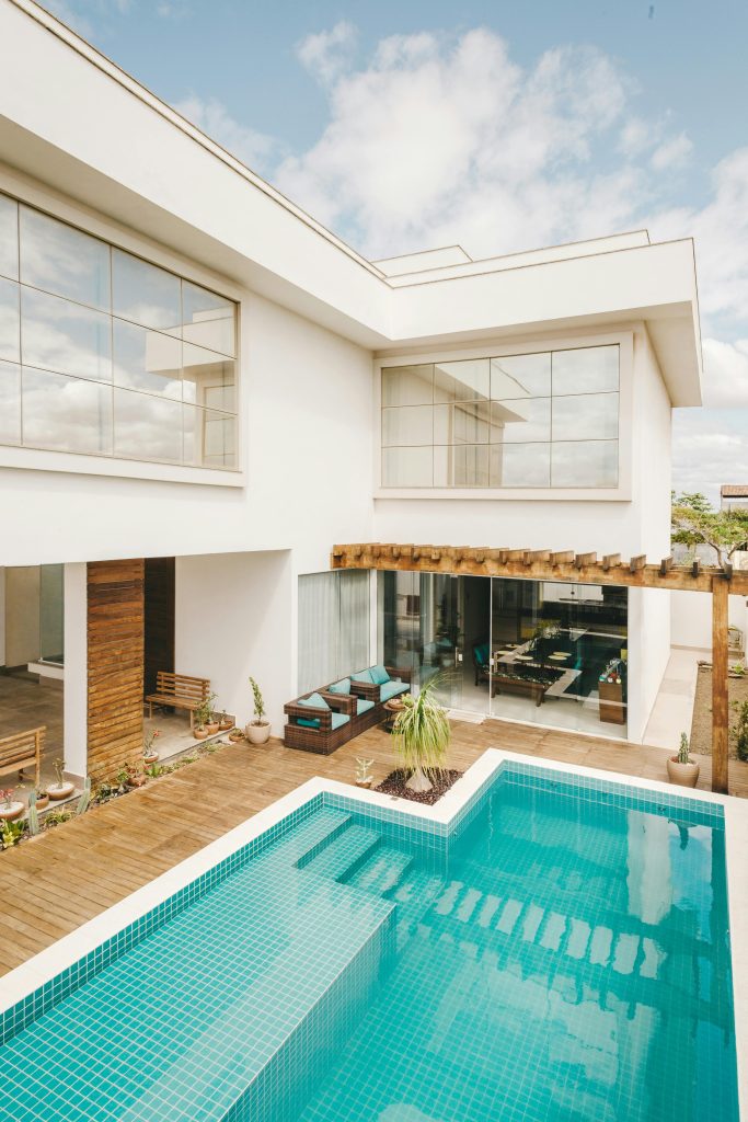 Contemporary interior of lounge area with swimming pool located on terrace of luxury villa in sunny day