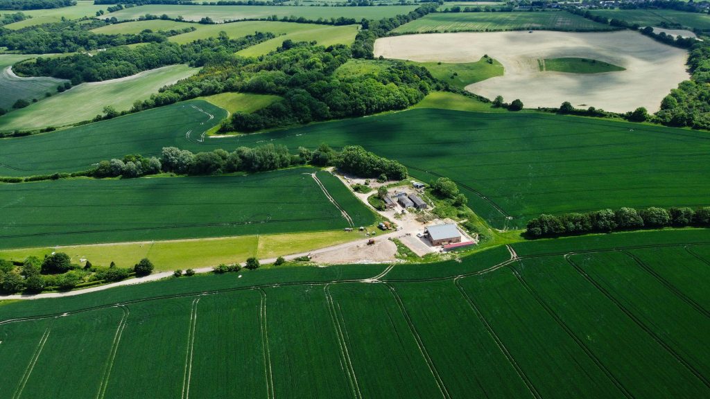 Aerial photo capturing lush green fields and farmland in Harlington, England.